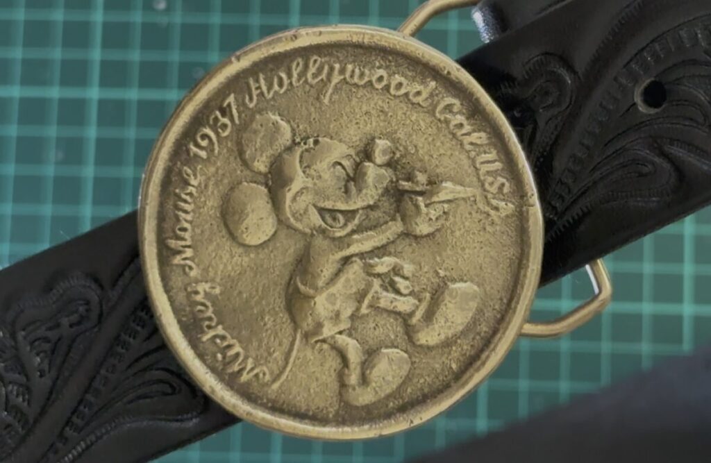 磨き上げられ、黄金色の輝きを取り戻したミッキーマウスの真鍮製バックル。