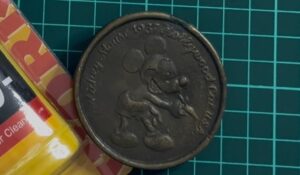 経年変化で黒ずんだヴィンテージの真鍮製ミッキーマウス・ベルトバックル。全体が酸化して茶褐色になっている様子。